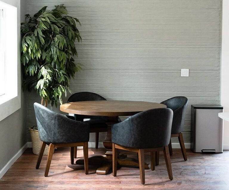 Dining room table and chairs next to a 3D printed wall